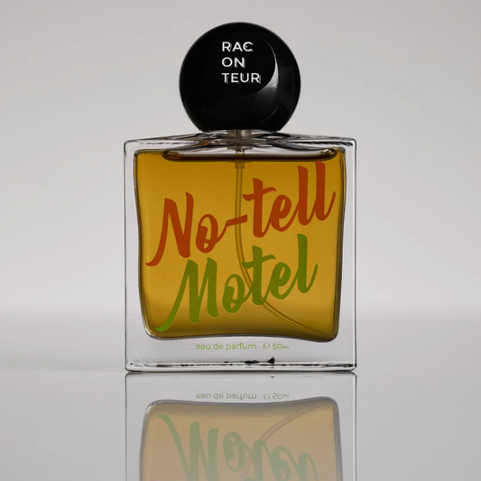 Perfume bottle labeled 'No-tell Motel' with a black cap on a reflective surface.